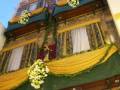 Fachada decorada con flores y cortinas en un edificio histórico.