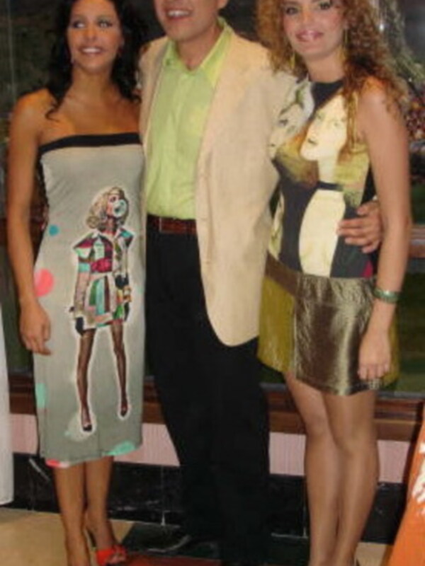 Tres personas posando juntos, dos mujeres y un hombre, vestidos con ropa elegante y moderna, en un entorno interno con decoración clásica.