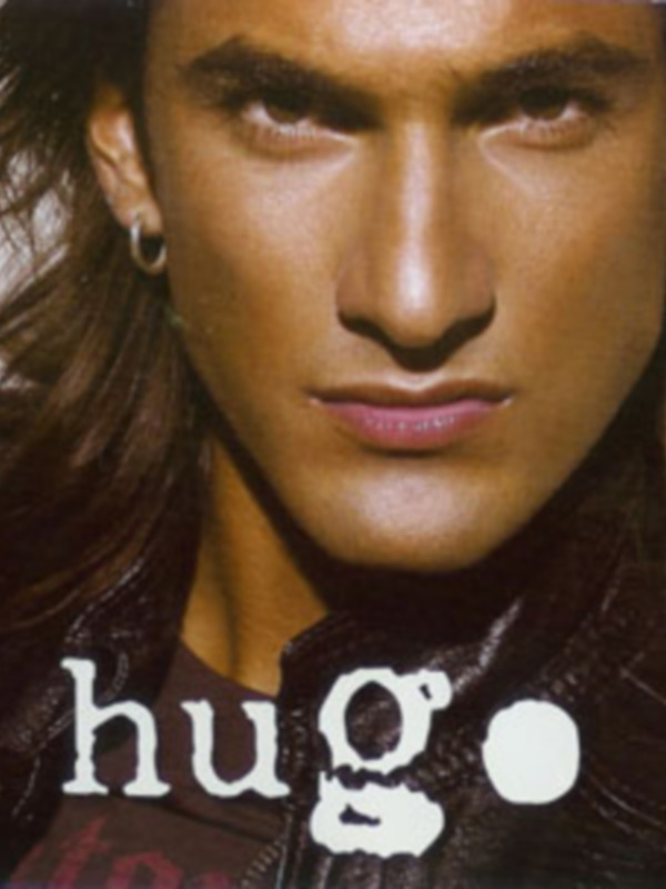 Portada de un álbum musical con el nombre 'Hugo' en letras grandes y un hombre con cabello largo y orejeras de metal.