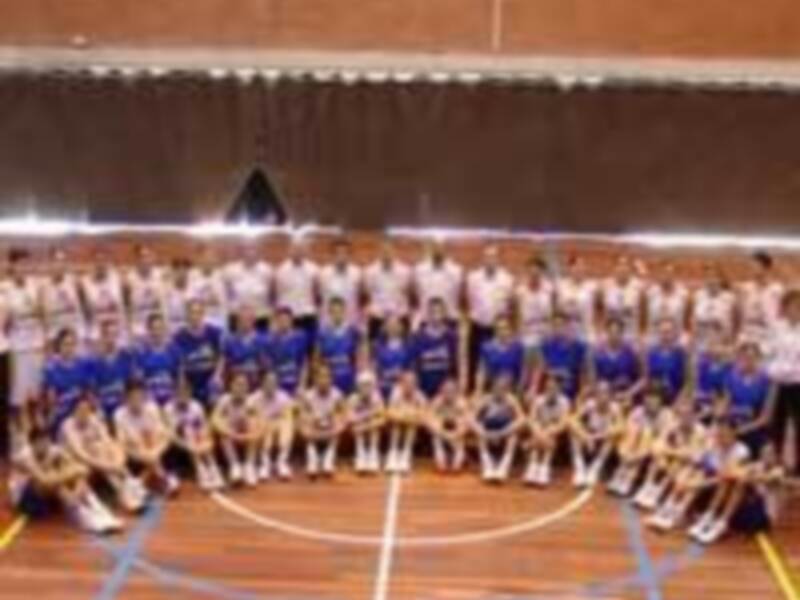 Equipo de baloncesto posando para una foto de equipo en una cancha de baloncesto.