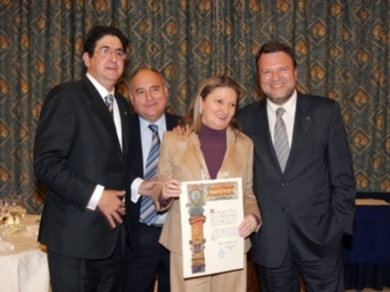 Celebración de un reconocimiento con un certificado en una reunión formal.