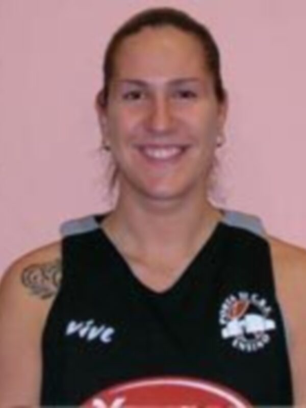 Joven mujer sonriendo, vistiendo una camiseta de baloncesto con el logo de Vive y un águila en el pecho.