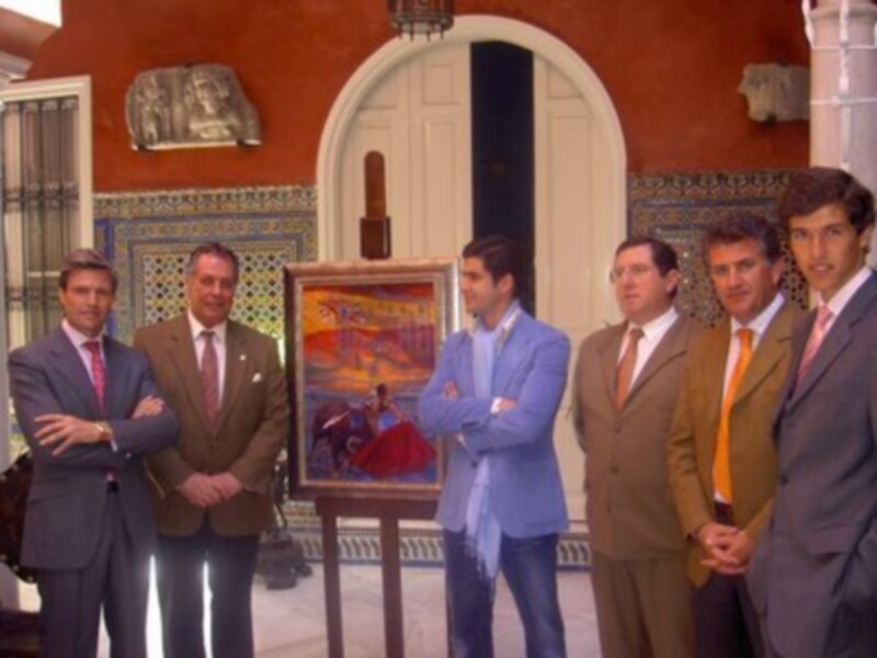 Grupo de hombres vestidos con trajes de negocios posando frente a una pintura de un caballo en un entorno de estilo colonial.