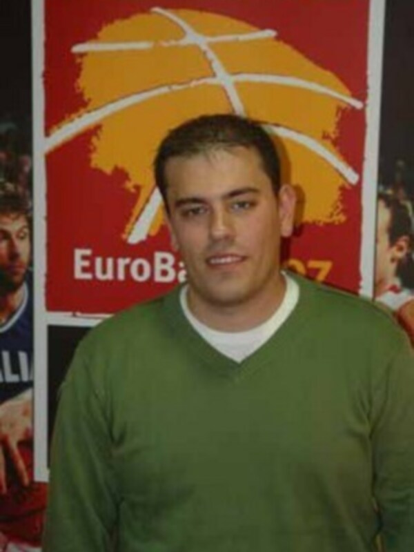 Persona joven en suéter verde frente a un cartel de EuroBasket 2007