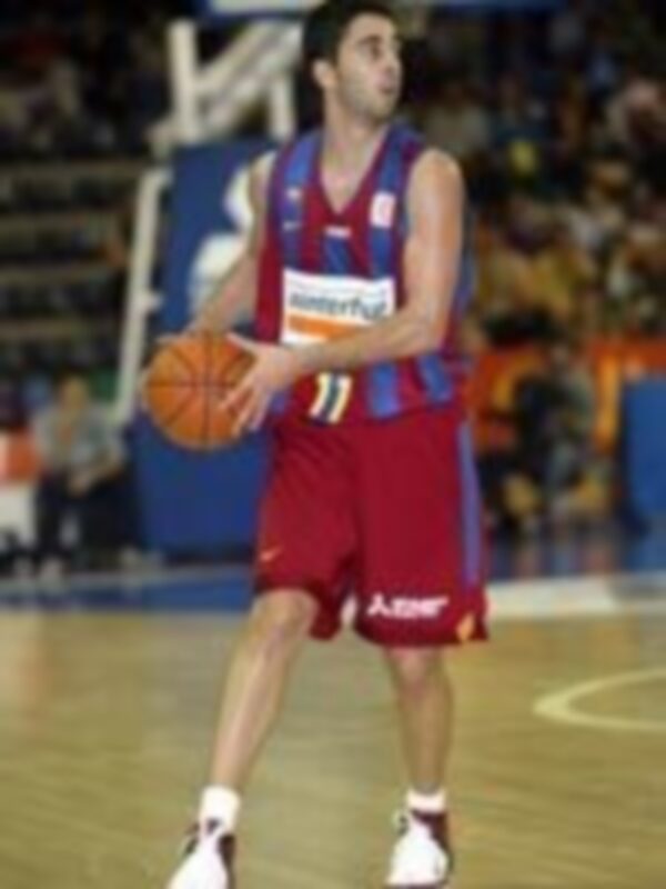 Jugador de baloncesto en acción, sosteniendo el balón durante un partido.