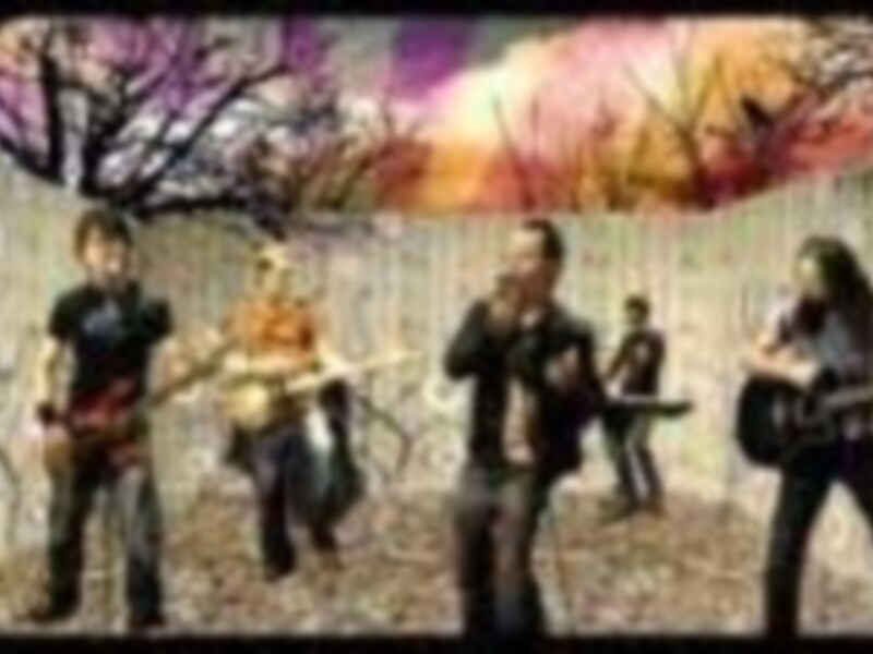 Una banda de rock en un escenario con un fondo de colores vibrantes y árboles en el aire.