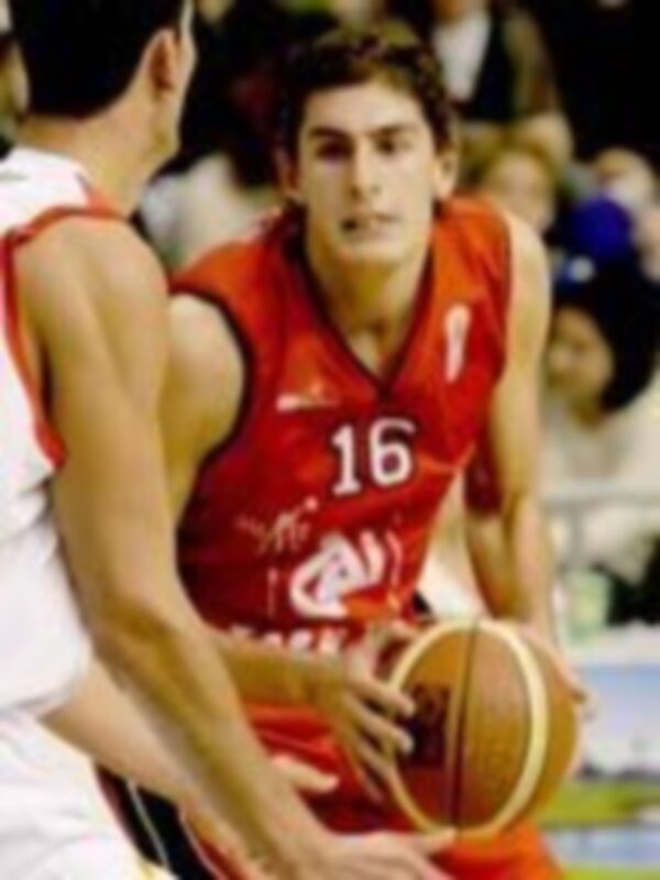 Jugador de baloncesto en acción durante un partido, con el número 16 en la camiseta roja.