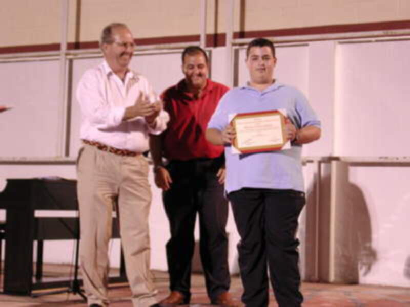 Persona recibiendo un certificado en una ceremonia de premiación.