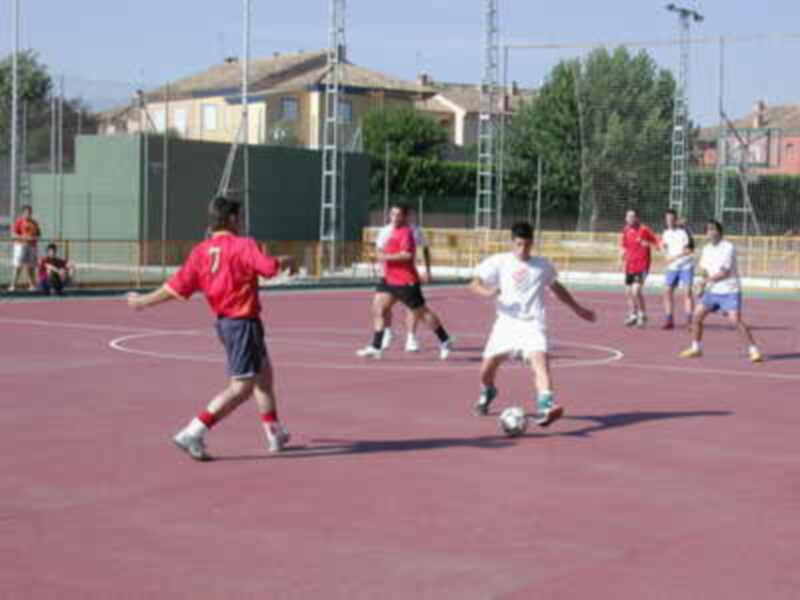 Jugadores en un partido de fútbol en una cancha al aire libre.