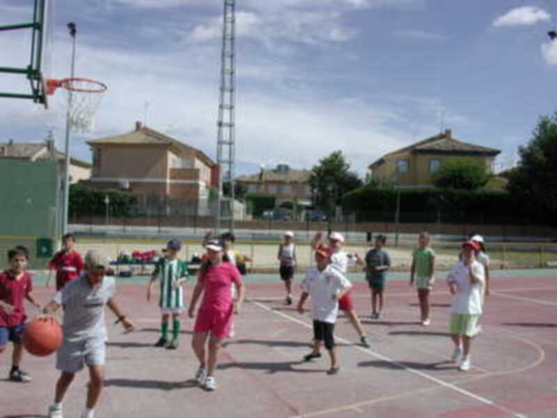 Jugadores de baloncesto en un partido local en un campo al aire libre.