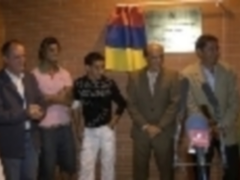 Reunión de personas en un espacio con banderas de Colombia y Ecuador, posando para una foto oficial.