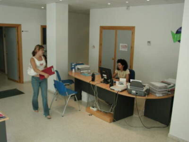 Oficina moderna con personal trabajando y documentos organizados en el escritorio.
