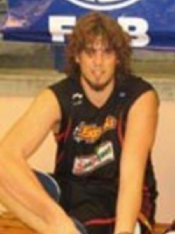 Un jugador de baloncesto en una cancha de baloncesto, posando para la foto.