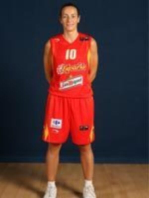 Jugador de baloncesto en uniforme rojo y blanco, posando con brazos cruzados.