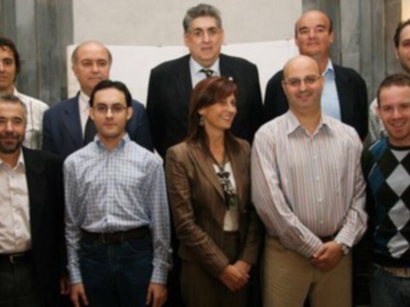 Grupo de profesionales posando para una foto en un ambiente formal, posiblemente en una conferencia o evento profesional.