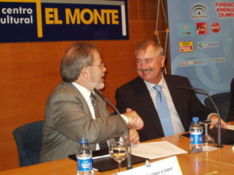 Dos hombres en traje saludándose en una reunión formal en el Centro Cultural El Monte.