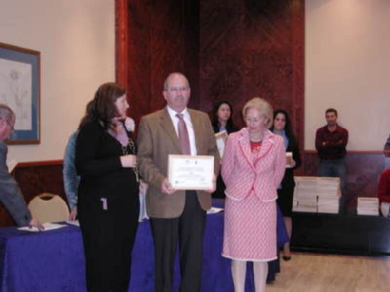 Persona recibiendo un certificado en una ceremonia formal.