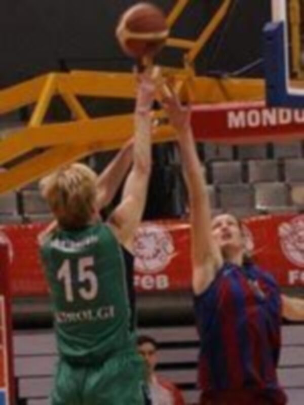 Un jugador de baloncesto en acción, con el nombre 'MONDIAL' visible en el fondo. El jugador parece estar en el aire, posiblemente intentando un tiro o una asistencia.