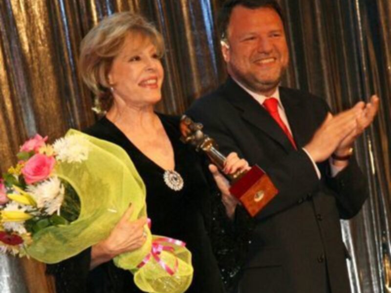 Premio a la Excelencia en el escenario, celebración con flores y aplausos.