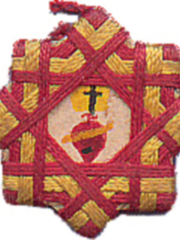 Emblema religioso con símbolo del corazón y cruz, bordado en rojo y amarillo.