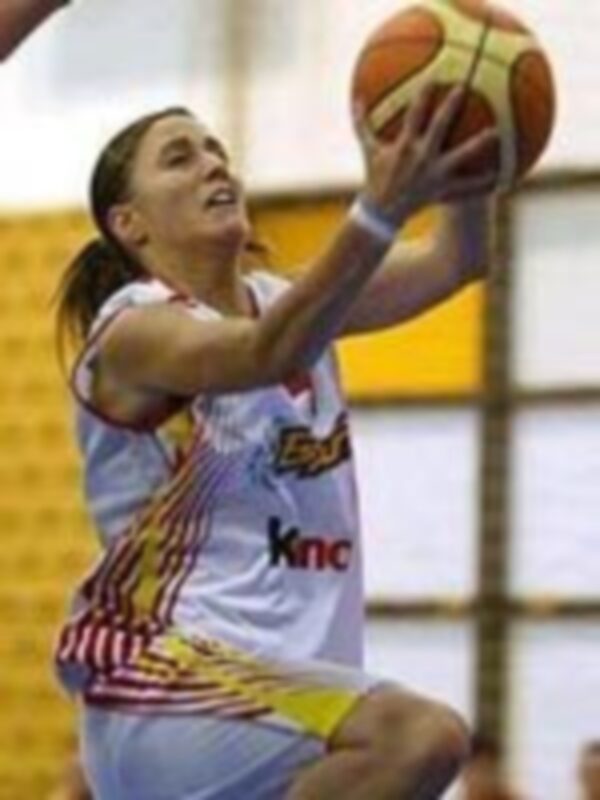 Joven jugadora de baloncesto en acción, vestida con uniforme blanco y rojo, capturada en un momento de intensidad durante un partido.