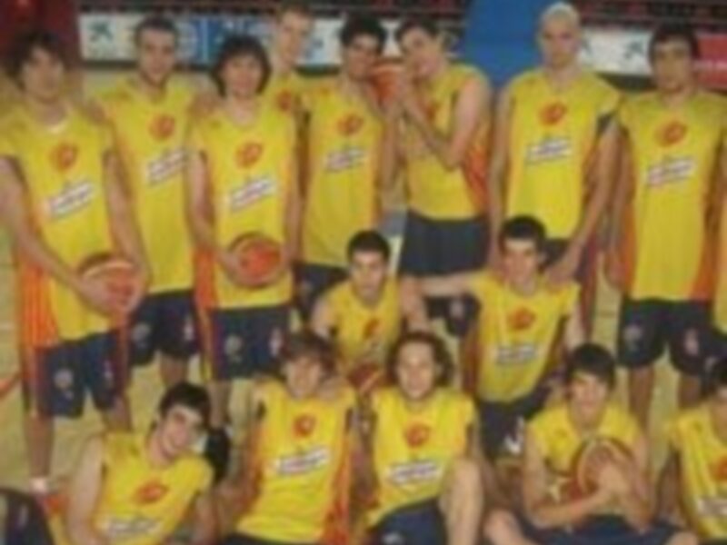 Equipo de baloncesto en uniforme amarillo con logos de sponsors en la camiseta.