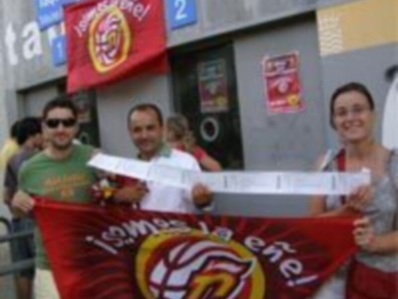 Personas con banderas y pancartas en una calle, posiblemente durante una manifestación o celebración.
