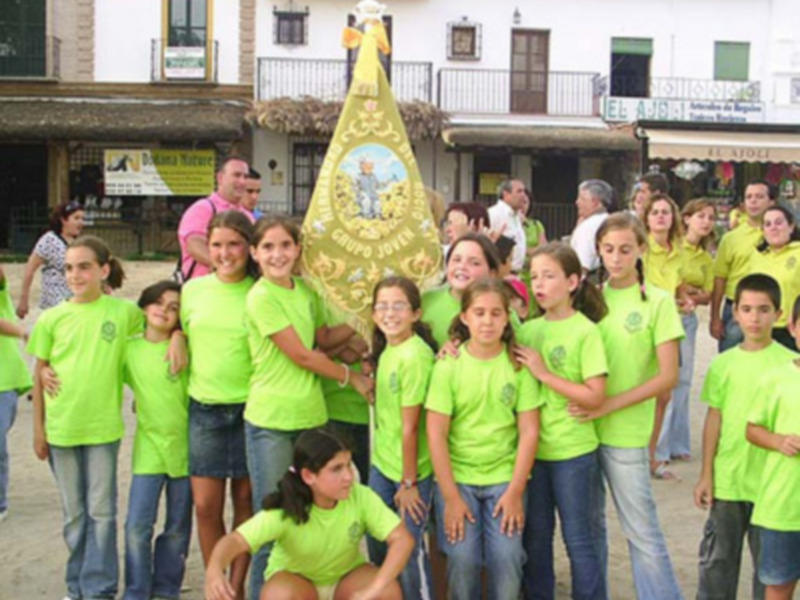 Niños vestidos de verde posando para una foto en una calle de una ciudad.