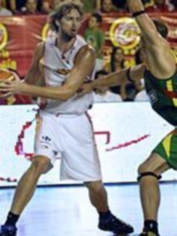 Jugador de baloncesto en acción durante un partido, mostrando habilidades de manejo de balón y defensa.
