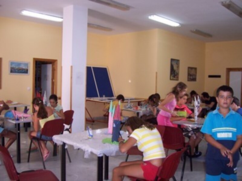 Niños participando en una actividad artística en un aula bien iluminada y organizada.
