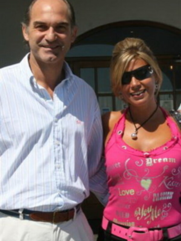 Una pareja sonríe juntos en un entorno al aire libre, con una mujer luciendo una camiseta rosa con detalles de amor y felicidad.