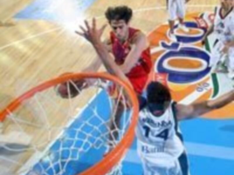 Jugador en acción durante un partido de baloncesto, intentando anotar en el aro.