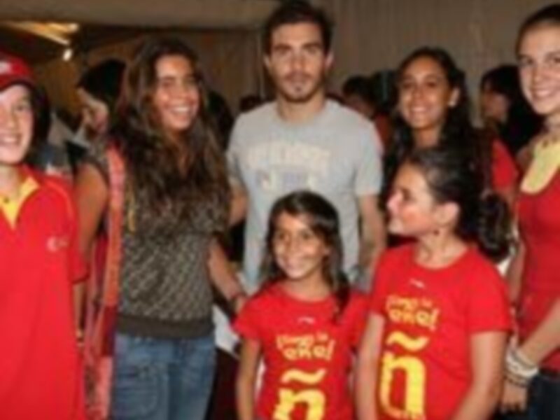 Una familia feliz en una fiesta, todos vestidos de rojo, sonriendo y disfrutando la ocasión.