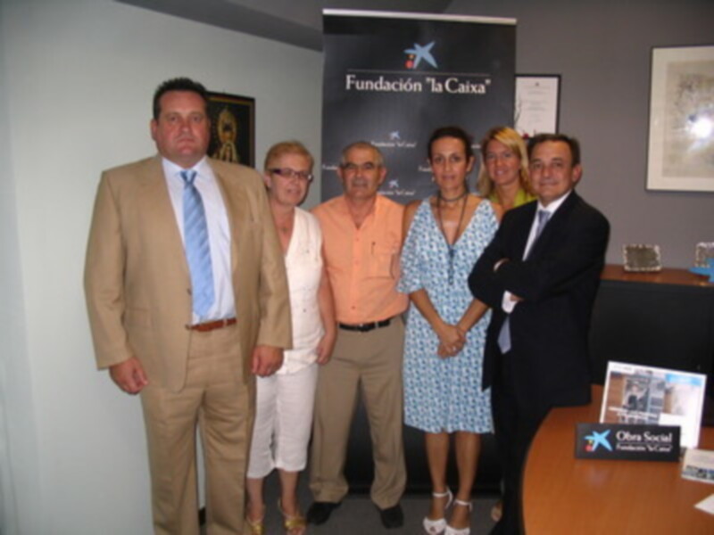 Grupo de personas posando frente a la Fundación 'la Caixa' en una reunión o evento profesional.