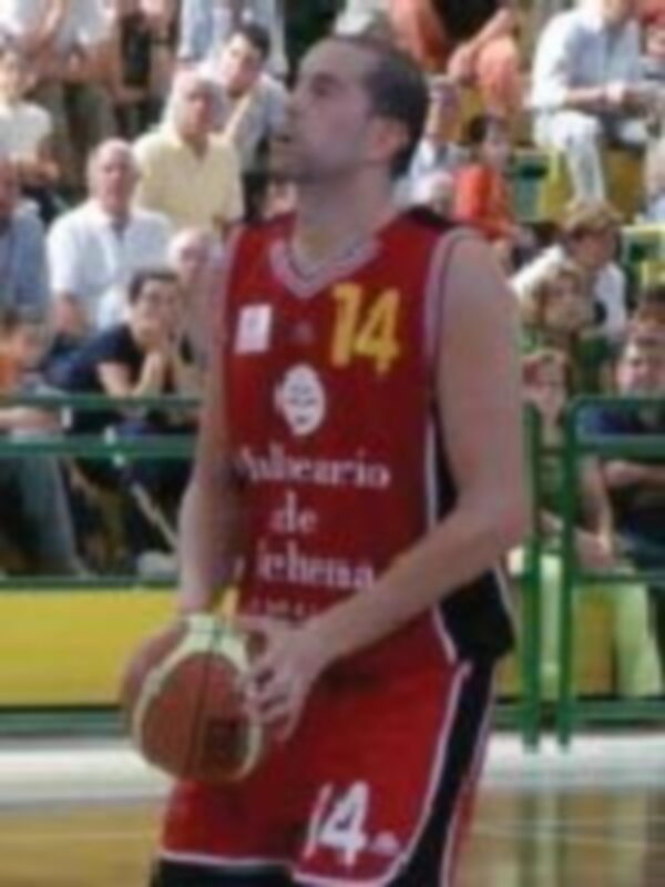 Un jugador de baloncesto en acción durante un partido, con el número 14 en su camiseta.