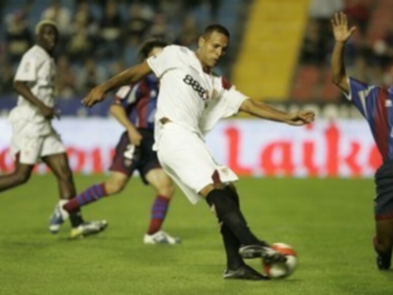 Jugador en acción durante un partido de fútbol, controlando el balón en el campo.