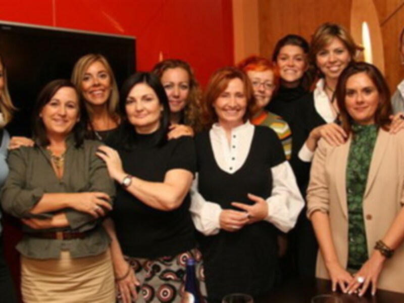 Una reunión de trabajo en una oficina con varias personas vestidas de manera profesional.