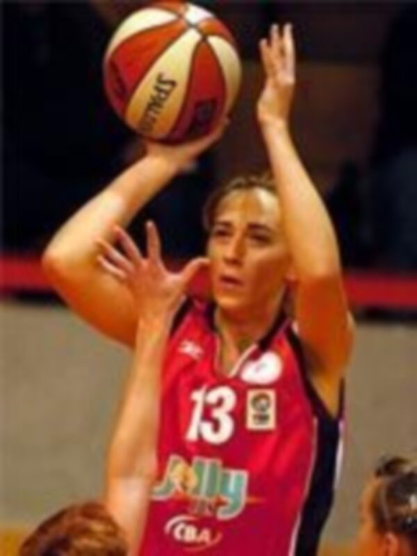 Jugadora de baloncesto en acción, lanzando el balón durante un partido.