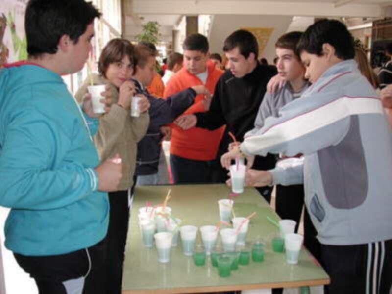 Jóvenes participando en una actividad de experimentación científica en un ambiente educativo.