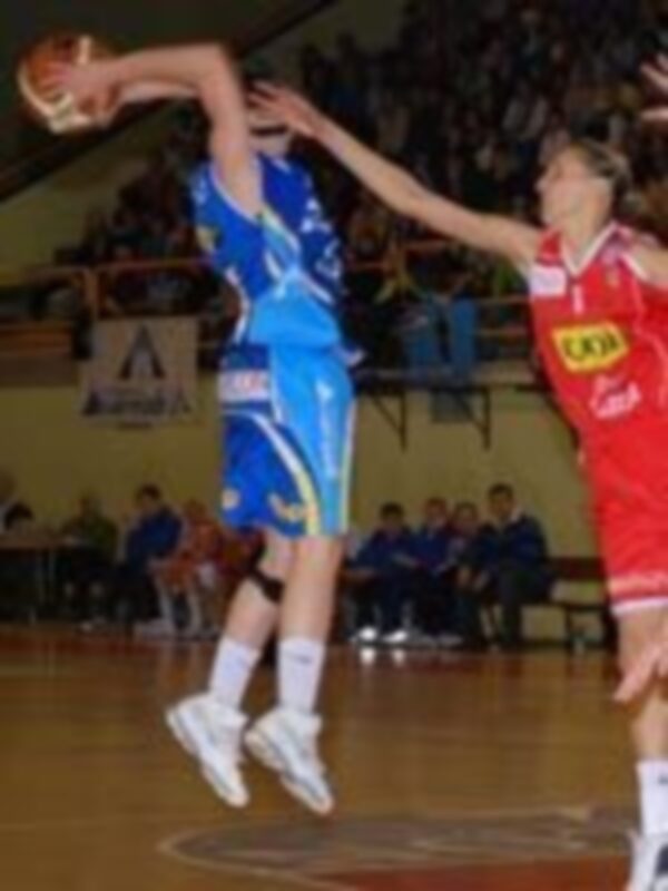 Jugador en acción durante un partido de baloncesto, saltando para un rebote.