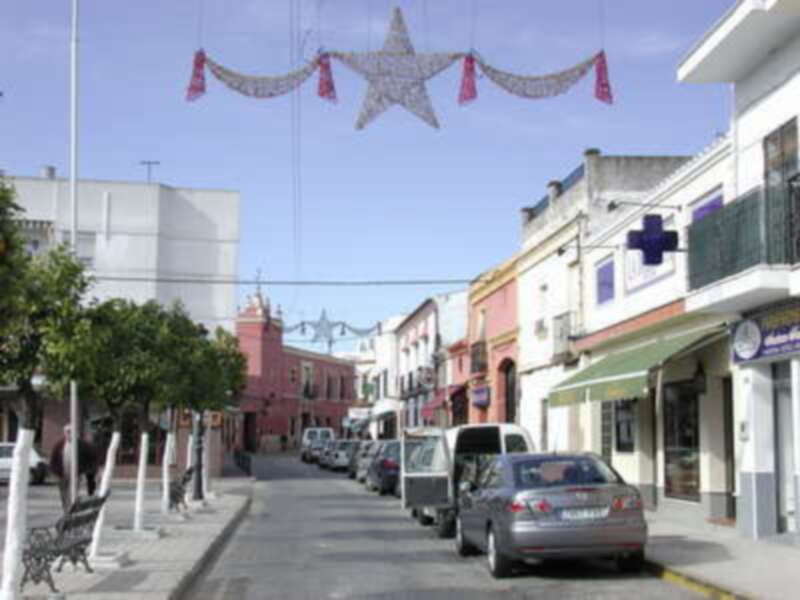 Calle decorada con estrellas navideñas, típica de una ciudad española con edificios coloridos y tiendas locales.