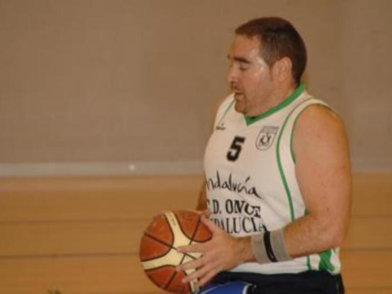 Un jugador de baloncesto con una camiseta verde y el número 5, sosteniendo un balón en una cancha de baloncesto.