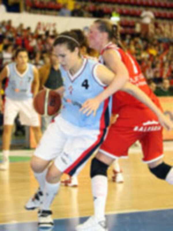 Jugadoras de baloncesto en acción durante un partido, con una defensa intensa y un ataque en movimiento.