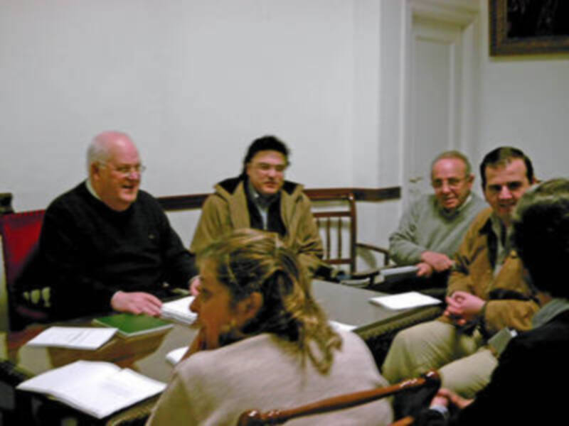 Reunión de trabajo en un ambiente formal con documentos y discusiones en curso.