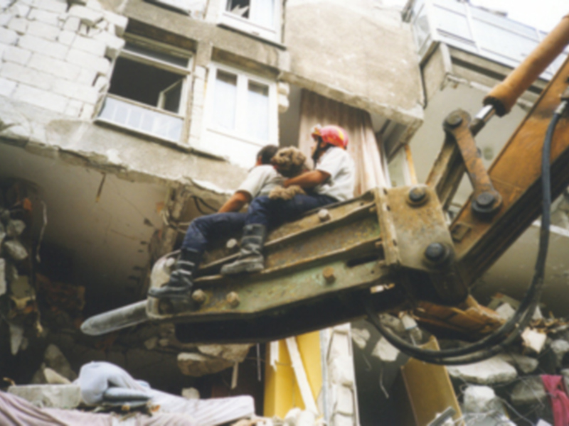 Trabajadores en una obra de demolición, sosteniendo una herramienta de construcción en un aparente momento de descanso.