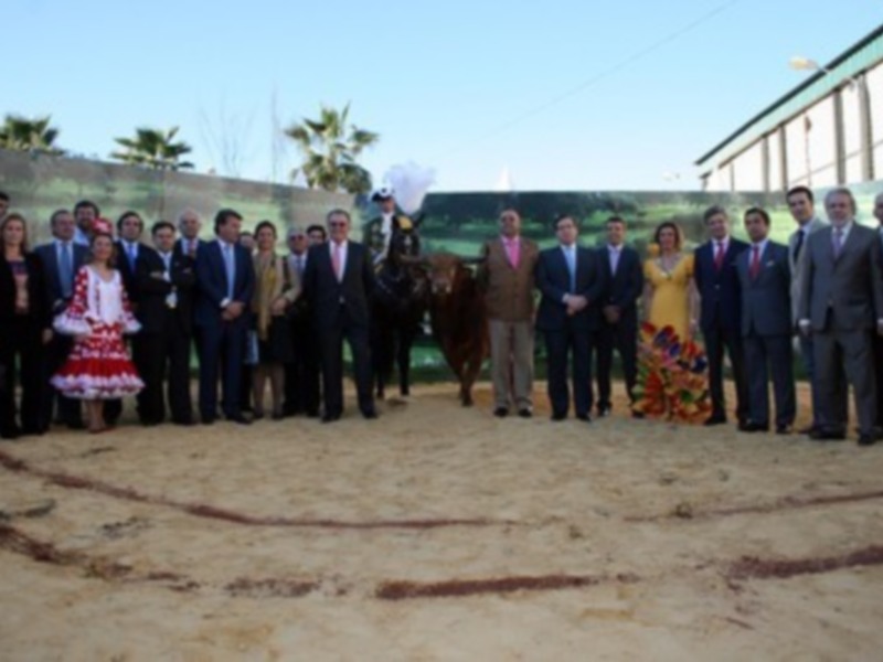 Celebración en un ruedo de toros con una persona montada en un caballo y un grupo de personas posando para una foto.