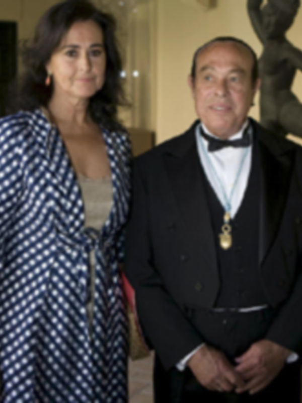 Una pareja en trajes formales posando para la foto.