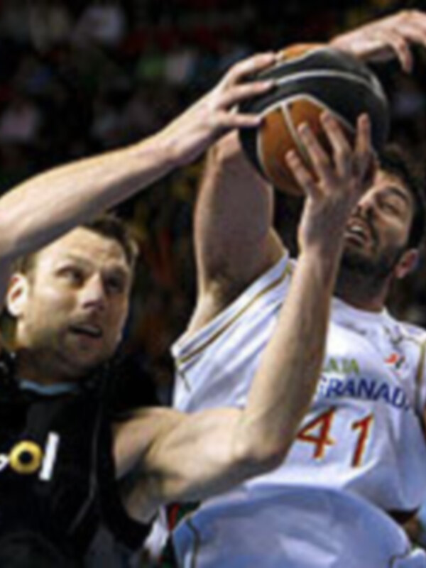 Un jugador de baloncesto en acción, con el número 41 en el uniforme, luchando por el balón con un oponente.