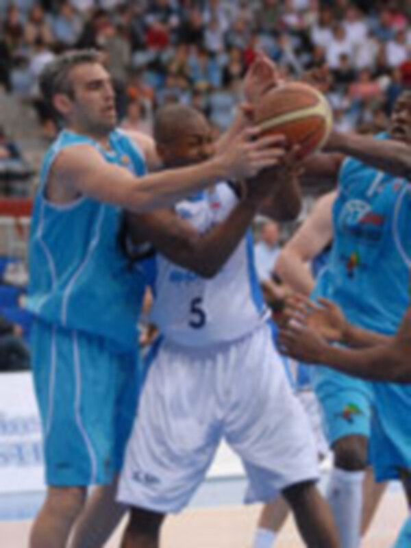 Juego de baloncesto en un campo de juego, con jugadores en acción y una camiseta azul con el número 5 en el fondo.