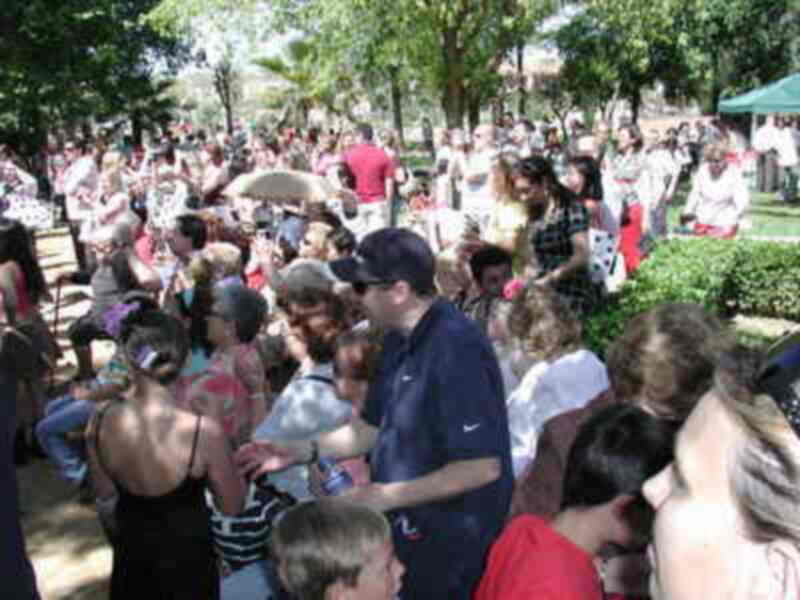 Celebración en un parque con gente disfrutando de un evento al aire libre.